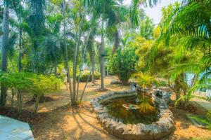 a pond in the middle of a park with palm trees at OYO 614 Koh Lak Resort in Prachuap Khiri Khan