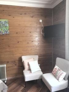 ein Wohnzimmer mit 2 Stühlen und einem Flachbild-TV in der Unterkunft Le papangue in Salazie