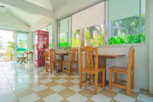 a dining room with tables and chairs and windows at OYO 614 Koh Lak Resort in Prachuap Khiri Khan