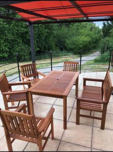 einen Holztisch und zwei Stühle sowie einen Tisch und Bänke in der Unterkunft La Tourouzelle in Lauraguel