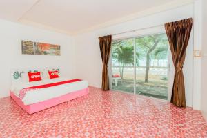 a bedroom with a bed and a large window at OYO 614 Koh Lak Resort in Prachuap Khiri Khan