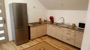 a kitchen with a stainless steel refrigerator and wooden cabinets at Apartamenty Daisy in Goczałkowice-Zdrój +46 photos
