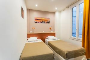twee bedden in een kamer met twee ramen bij Relaxhome - Hypercentre - Clim - Netflix in Cannes