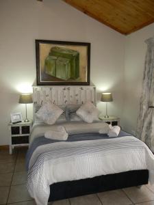 a bedroom with a large bed with a painting on the wall at Ridderspoor Guesthouse in Middelburg