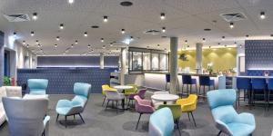 a restaurant with tables and chairs and a bar at Hotel Adler Münster in Münster