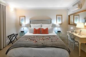 una camera da letto con un grande letto con fiori di Auberge Daniella a Franschhoek
