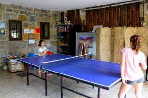duas crianças a jogar pingue-pongue numa sala com uma mesa em Casa rural Mertxenea Landetxea em Elcano