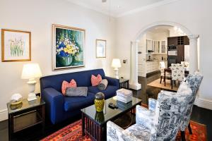 un soggiorno con divano blu e sedie di Auberge Daniella a Franschhoek