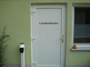 una puerta blanca con las palabras lindisfarne en Ferienhäuser Stübgen, en Burg