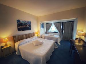 a hotel room with two beds and a window at Puntaquattroventi in Ercolano