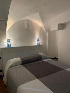 ein Schlafzimmer mit einem Bett in einem weißen Zimmer in der Unterkunft Vacanza al Ponte Reale in Genua