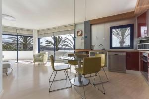 a kitchen and living room with a table and chairs at Merlín 1-1 in Playa de San Juan