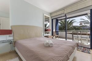 a bedroom with a bed with two white towels on it at Merlín 1-1 in Playa de San Juan