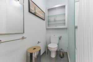 a bathroom with a toilet and a mirror at Merlín 1-1 in Playa de San Juan +17 photos