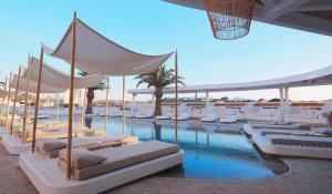 una piscina con sedie bianche e una piscina di Andronikos Hotel a Mykonos Città