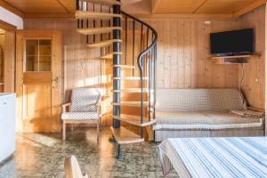 una sala de estar con una escalera de caracol y una silla en App Peterbühl - Gasser en Vols am Schlern