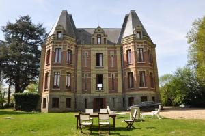 a large brick building with a table in front of it at Château De La Croix Bizet in Moulineaux