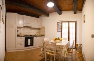 a kitchen with a table and a kitchen with white cabinets at Casa Vacanze Porta Manfredi in Arce