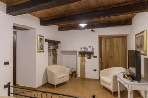 ein Wohnzimmer mit 2 Stühlen und einem TV in der Unterkunft Casa Vacanze Porta Manfredi in Arce
