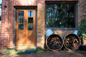 a brick house with a wooden door and two logs at The Getaway Roleystone in Roleystone