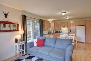 a living room with a blue couch and a kitchen at Tranquility Lodge by Instant Suites in Mont-Tremblant