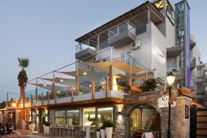 Un grand bâtiment blanc avec balcon est disponible. dans l'établissement Elounda Akti Olous (Adults Only), à Elounda