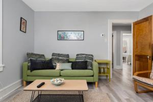 a living room with a green couch and a table at Large Beach Home with Ocean Views from Balcony Unit 2 and 3 in Ventnor City