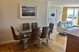 a dining room with a table and chairs and a couch at Barton on Sea self contained, stunning sea views in Barton on Sea