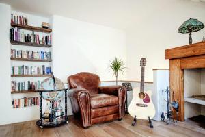 a living room with a chair and a guitar at House Of Dreams - The House Of Travelers in Como