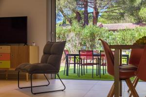 - un salon avec des chaises, une table et une télévision dans l'établissement Les Pins de Santa Giulia, à Porto-Vecchio