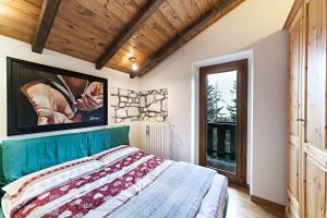 a bedroom with a bed and a large window at Chalet Mirastelle in Pretoro