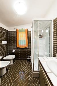 ein Badezimmer mit 2 Waschbecken, einer Dusche und 2 WCs in der Unterkunft Chalet Mirastelle in Pretoro