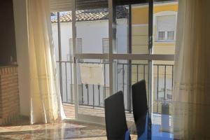 Habitación con vistas a un balcón con cortinas. en Lucena-Piso amplio y luminoso, en Lucena