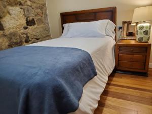a bedroom with a bed with a blue blanket on it at CASA O´PACIÑO in Vigo