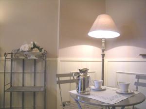 Bed & Breakfast Sant'Erasmo في بيرغامو: طاولة عليها مصباح وغلاية شاي