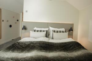 1 dormitorio con 1 cama grande con almohadas blancas en Hämeenkylän Kartano en Vantaa