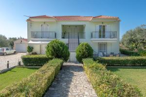 a large white house with bushes in front of it at Vista Verde Studios, Svoronata in Svoronata