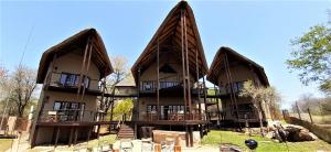 duży budynek z dwoma dużymi dachami gambrel w obiekcie Kruger Private Lodge w mieście Marloth Park