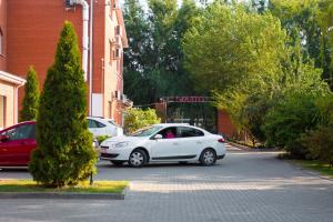 un coche blanco estacionado frente a un edificio en Meridian-Yug Hotel, en Krasnyy Kolos