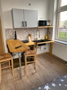 a kitchen with a table and chairs and a sink at Zollzeche Stadtwohnungen in Staßfurt +28 photos