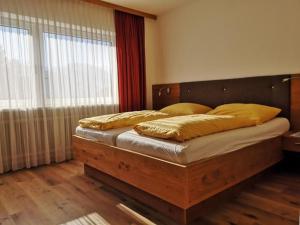 a bedroom with a large bed with a wooden headboard at Gästehaus Braunegger in Stumm