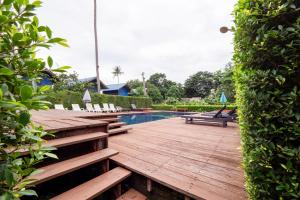 une terrasse en bois avec des chaises et une piscine dans l'établissement OYO 75340 Klkl Hostel, à Ko Chang