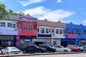 una fila di edifici con auto parcheggiate in un parcheggio di OYO 89820 Sp Berlian Inn a Sungai Petani