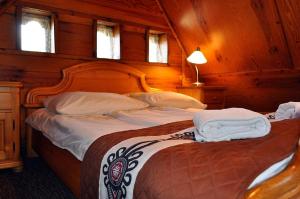 1 dormitorio con 2 camas, paredes y ventanas de madera en Willa Orla, en Zakopane