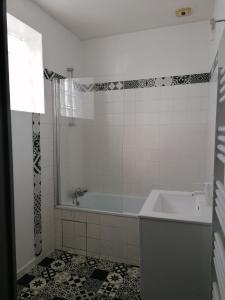 y baño con bañera, ducha y lavamanos. en Appartement meublé proche du futuroscope, en Poitiers
