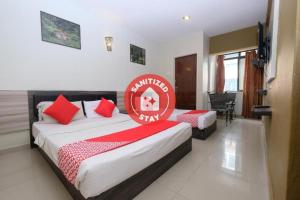 ein Hotelzimmer mit 2 Betten und roten Kissen in der Unterkunft Super OYO 1153 Heaven Hill Hotel 1 in Cameron Highlands