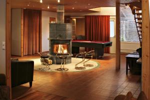 a living room with a fireplace and a piano at Vuokatin Aateli Villa Tsaari in Vuokatti