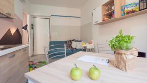 kuchnia ze stołem z dwoma zielonymi jabłkami w obiekcie Babyaccommodation Family Panoramic II w mieście Pietra Ligure