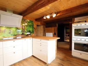 a kitchen with white cabinets and a wooden ceiling at Ferienhütte Biobetrieb Lippenhof in Breitnau