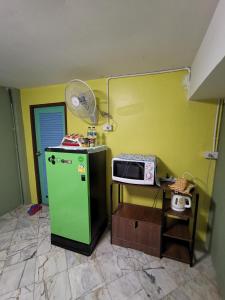 eine Küche mit einem grünen Kühlschrank und einer Mikrowelle in der Unterkunft อารมย์ดี อพาทเม้นท์ ขอนแก่น in Ban Nong Waeng